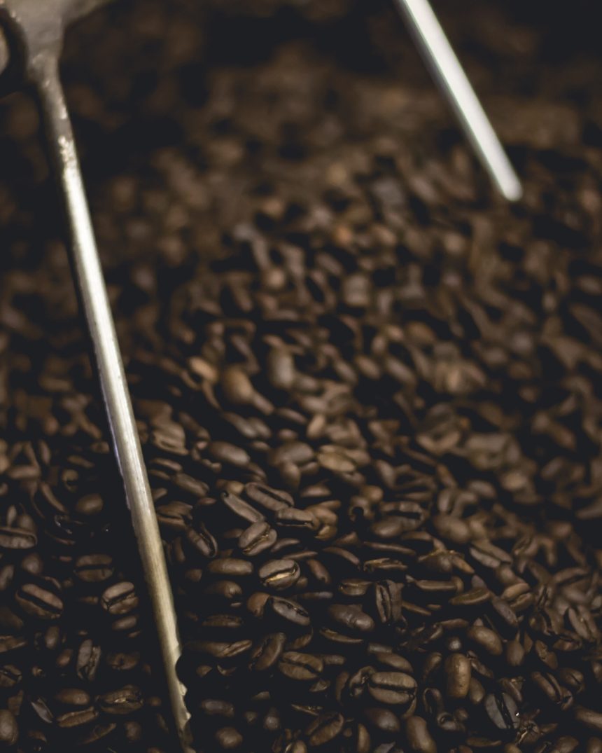 Dark roasted coffee beans in a roasting drum, representing Gunung Kerinci Wet-Hulled