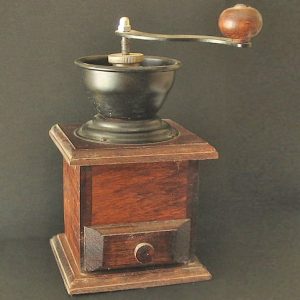 Small wood-cased manual coffee grinder with a top crank