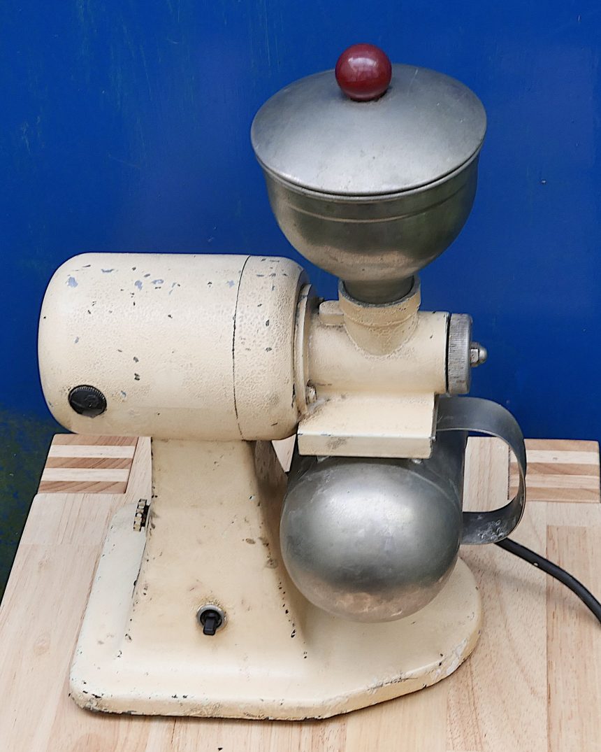 Vintage-style electric coffee grinder with a round motor housing