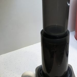 Plunger-style immersion coffee press seated on a mug