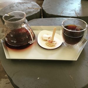 Glass pour-over carafe with volumetric markings on a serving tray