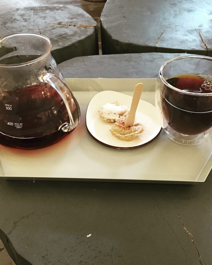 Glass pour-over carafe with volumetric markings on a serving tray