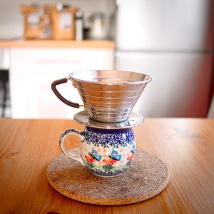 Flat-bottom wave-style dripper with ribbed metal cone sitting on a mug