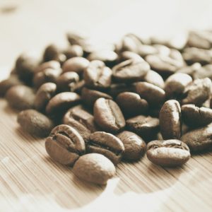 Light-roasted coffee beans on a wooden surface, evoking the jasmine and bergamot notes of Werka Chelchele Yirgacheffe