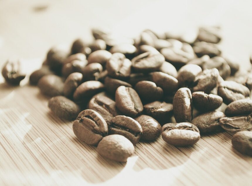 Light-roasted coffee beans on a wooden surface, evoking the jasmine and bergamot notes of Werka Chelchele Yirgacheffe
