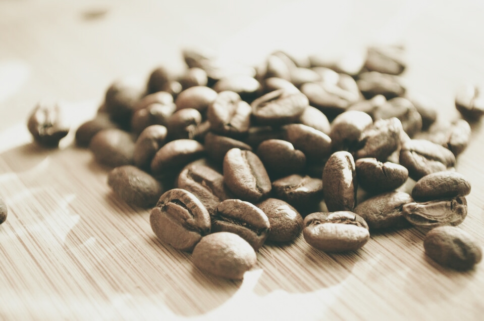 Light-roasted coffee beans on a wooden surface, evoking the jasmine and bergamot notes of Werka Chelchele Yirgacheffe